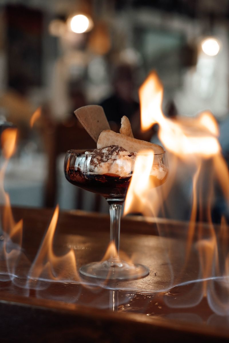 Flambiertes Dessert mit brennender Flamme im Glas