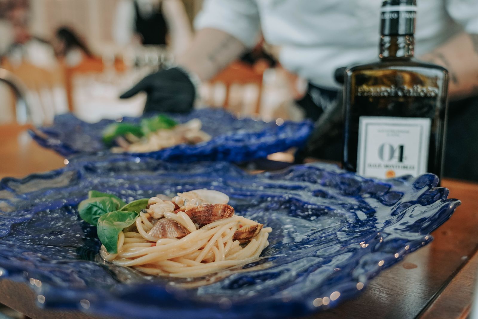Hausgemachte Pasta auf blauem Keramikteller mit Olivenöl
